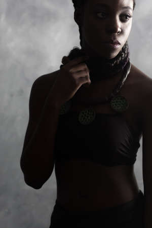 confident calm black woman with long braids. studio contrast portraitの写真素材