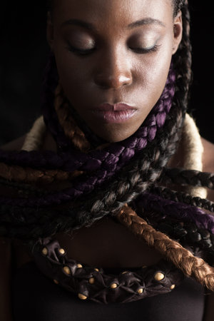 ace of  afro-american woman with ethnic hairstyle. Her neck wrapped with colored long braids