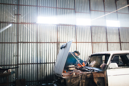 Service station for old damaged automobile. Bodywork and restore body and engine compartment....