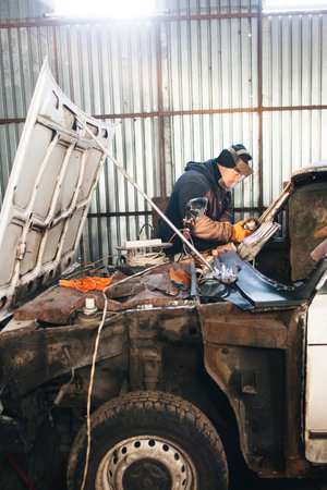 Service station for old damaged automobile. Bodywork and restore body and engine compartment....