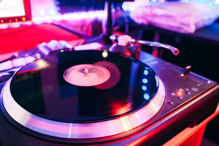 Closeup of turntable playing vinyl deck in nightclub light with nobodyの写真素材