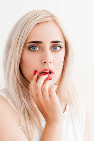 Surprised shoked girl covers her mouth and her eyes wide open. A conceptual photo on a white backgroundの写真素材