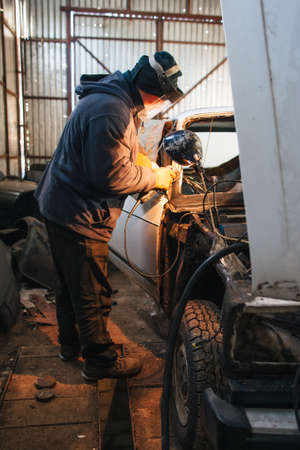 Service station for old damaged automobile. Bodywork and restore body and engine compartment. Workshop backgroundの写真素材