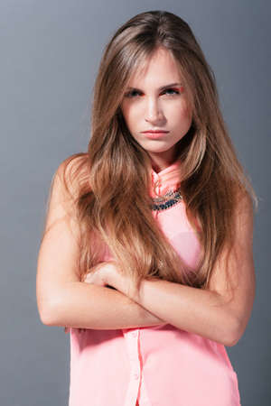 Angry girl shows her negative emotions.udio photo on a gray backgroundの写真素材