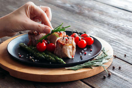 Chief decorating a pork dish. Waiter serving food for presentation to the client. Chief decorating  food for retail.の写真素材