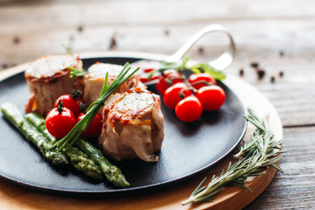 Delicious holiday dinner on a wooden table. Tasty holiday meat with fresh vegetables. Dinner in restaurant of mediterranean cuisineの写真素材