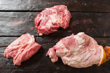 Sale of pieces of raw pork meat at the market. Sale pieces of raw pork meat on wooden table. Top view of pieces raw pork meat at the market.の写真素材