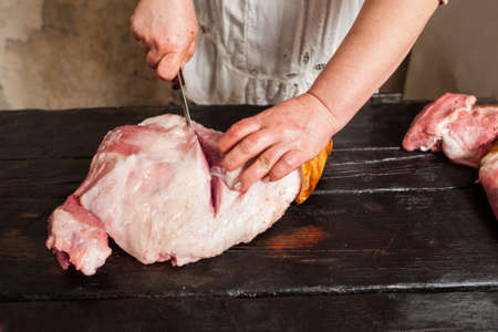 Slicing raw pork meat on piece in farm market.  Butcher slicing raw pork meat in local market. Top viewの写真素材
