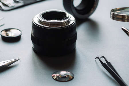 Precision optical dslr lens service, adjustment and alignment. Camera lens repair set in photo engineer workplace. Maintenance support of photographic 50 1.4 photo camera lens.の写真素材