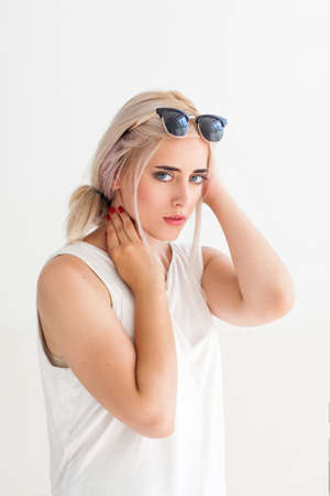 Fashion confident model in sunglasses. Beautiful young woman with sunglasses on head. Concept for advertisement, flyer, banner. Beautiful sexy girl in glasses looking at the cameraの写真素材