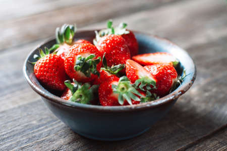 Bowl of fresh red strawberries on the wooden table. Close up. Fresh tasty mouth-watering red strawberries. Country styleの写真素材