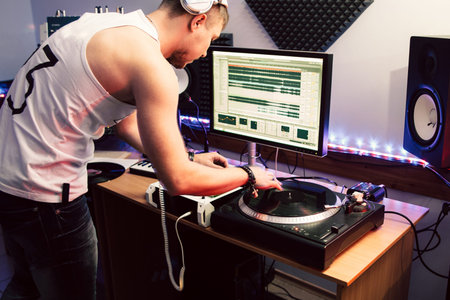 DJ creates composition in sound recording studio.  DJ playing music in sound recording studio...