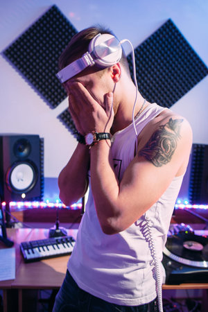 Tired DJ after hard work in sound recording studio. Sad DJ after exhausting overtime  in night club....