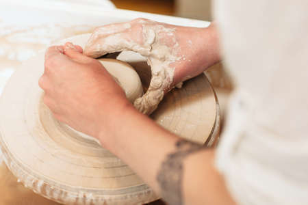 Potter hands shaping clay top view. Closeup on artisan hands making pottery. Art therapy processの写真素材