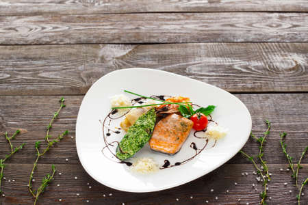 Mussle, grilled salmon, shrimp on wood copyspace. White plate with variety of seafood on wooden background. Free space and seafood mix plate.の写真素材