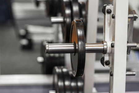 Weightlifting training device at gym close-up. Exercise mashine with barbell. Weight plate on barbell at gymの写真素材