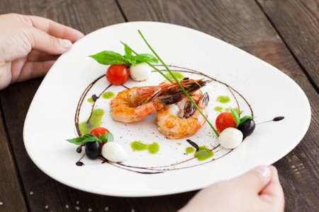 Plate with grilled shrimps taking from dark wooden table close-up, seafood meal cookingの写真素材