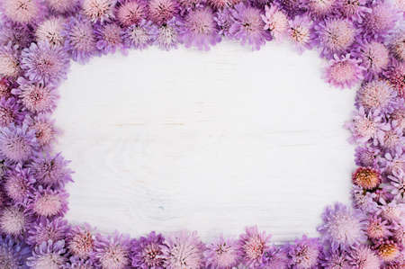 Frame of purple flowers on white, copyspace in center. Violet floral backdrop with free space for textの写真素材
