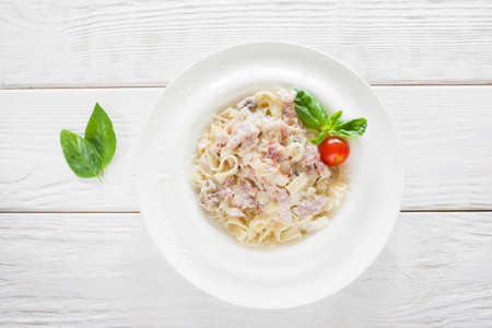 Spaghetti carbonara on white wooden background, flat layの写真素材