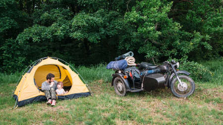 Father and daughter travel on motorbike to camping. Sidecar motorcycle trip with dad, free spaceの写真素材