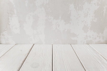 Old plaster wall with white wooden floor, close-up.の写真素材