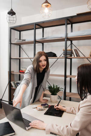 Managers discussing new digital project. Team work in office. Young ambitious women talking about startup ideasの写真素材