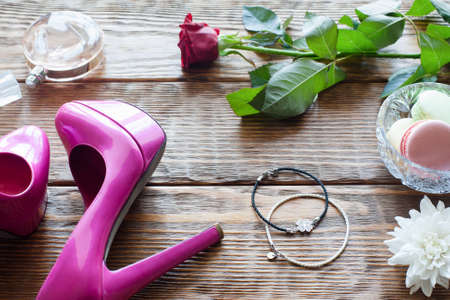 Female accessories on wooden background with sweets and flowers.の写真素材