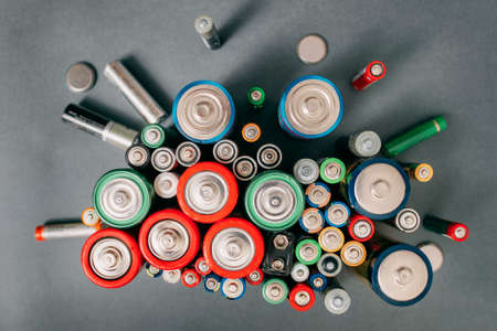 Colorful batteries on gray background, top view. Energy bright backdrop, close-upの写真素材