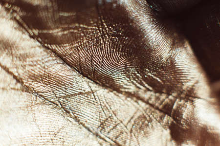 Patterns on golden human palms close-up. Painted hand with gold leaf. Gilded arm. Luxury body artの写真素材
