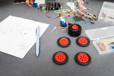 Components and scheme of constructing car at home. Engineer workplace with wiring diagram and wheels for toy truck, diy modeling, modern technologies, hobbyの写真素材