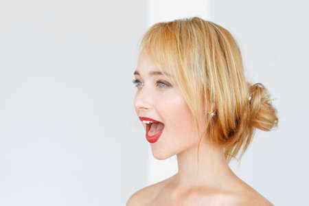 Adorable red-haired woman shouts with opened mouth. Impressed carroty girl feeling delight, free spaceの写真素材