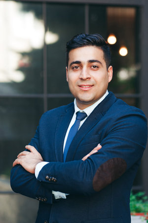 Prosperous entrepreneur with folded arms. Succeessful businessman portrait., modern glass building...