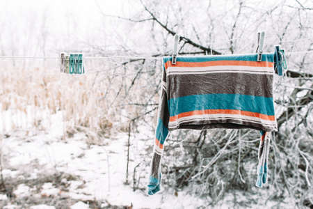Frozen pullover on clothesline outside. Strong russian winter. Cold, early frosts, hoar conceptの写真素材