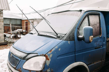 Old rusty truck on winter yard. Broken car in winter village.の写真素材