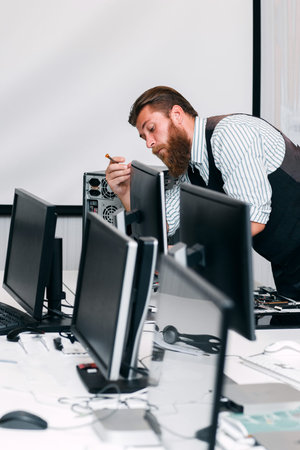 Repairman fixing computer monitor in office. Programmer fixing Screen for work in open space. Programming, repair, renovation conceptの写真素材