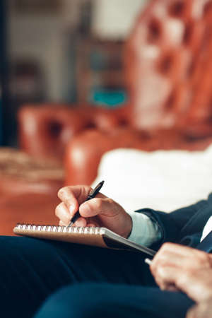Male hand writing plans in a notepad. Work planning. Making important decisions, projects. Arrangement.の写真素材