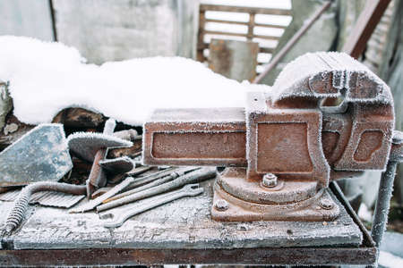 Frosted vise tool in outside workshop. Left outside tools in winter. Cold, early frosts, hoar conceptの写真素材