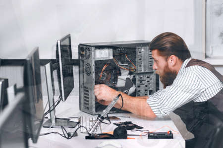 Repairman fixing computer, double exposure. Side view on engineer repairing CPU. Electronics repair, development, construction conceptの写真素材