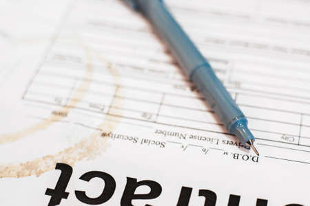 Pen on dirty contract paper close-up, business background. Close-up of documents of busy, and tired businessman.の写真素材