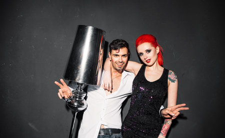 Happy man in white shirt posing for photo with informal girl on gray background. Redhead woman photographing with stranger at party.の写真素材