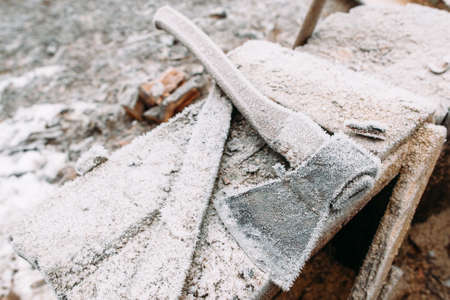 Close-up of frosted axe on wooden table. Mechanical instrument on workplace of handyman. Left outside tools in winter. Cold, early frosts, hoar conceptの写真素材