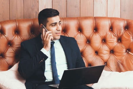 Happy businessman talking on the phone, free space. Business and finance concept. Investment. Coworking.の写真素材