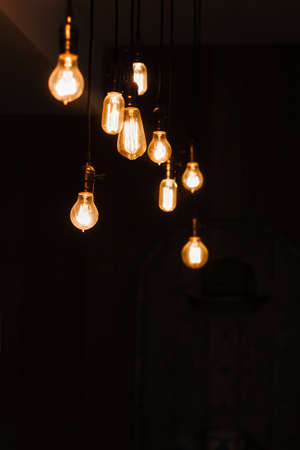 Incandescent lamps in a modern loft. Edison lamp composition on dark background, free space for text or advertisement. Teamwork, idea, creativity, light conceptの写真素材