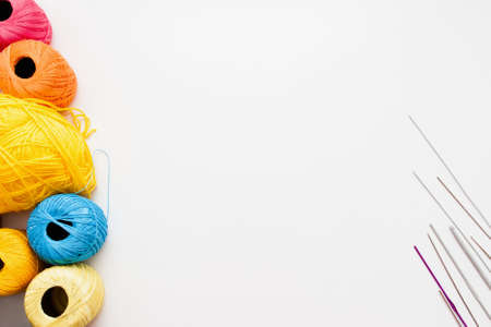 White background with knitting thread and needles, free space. Colorful strings and accessories for handiwork on white background, copy space for text or advertisement.の写真素材