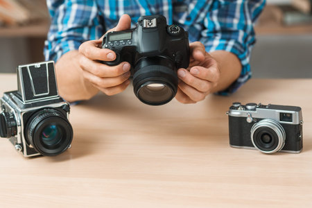 Modern digital camera presentation close-up. Unrecognizable blogger talking about photographer work....