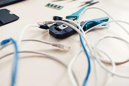 Forceps for crimping modular plug with internet cables on table. Network development, telecommunications, business conceptの写真素材