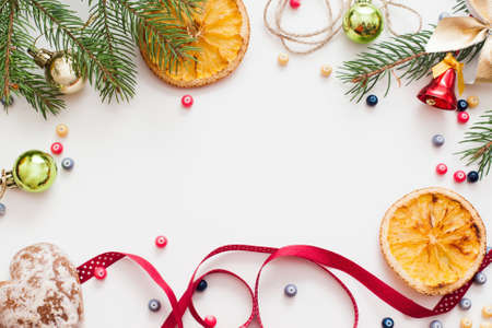 Christmas decoration and citrus frame, free space. Festive composition of xmas trumpery and dried lemon on white background, copy space for text or advertisementの写真素材