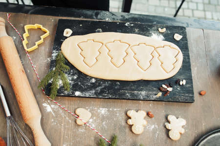 Christmas cookies from dough cooking. Top view on tray with gingerbread treat preparing. Winter holidays, xmas spirit, culinary, homemade cuisine conceptの写真素材