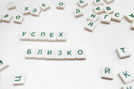 Success Is Close phrase in russian  blocks. Motivational wish constructed from crossword blocks on white backgroundの写真素材
