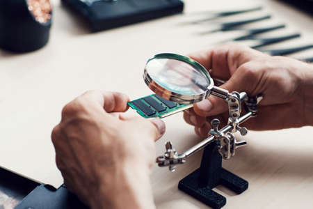 Magnifier in electronic repair shop. Special equipment for studying and renovation broken microcircuitsの写真素材